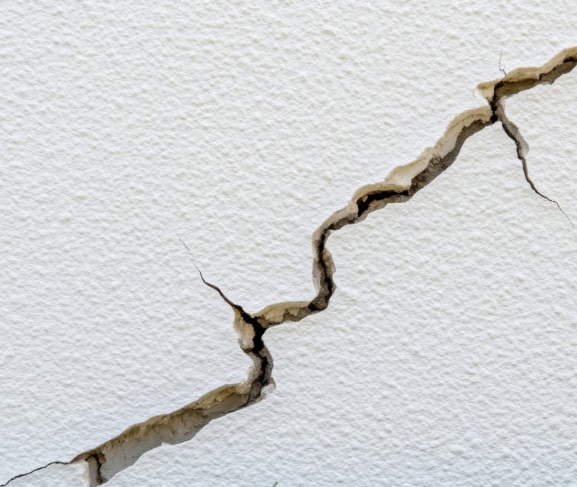 diagonal crack in a white stucco wall